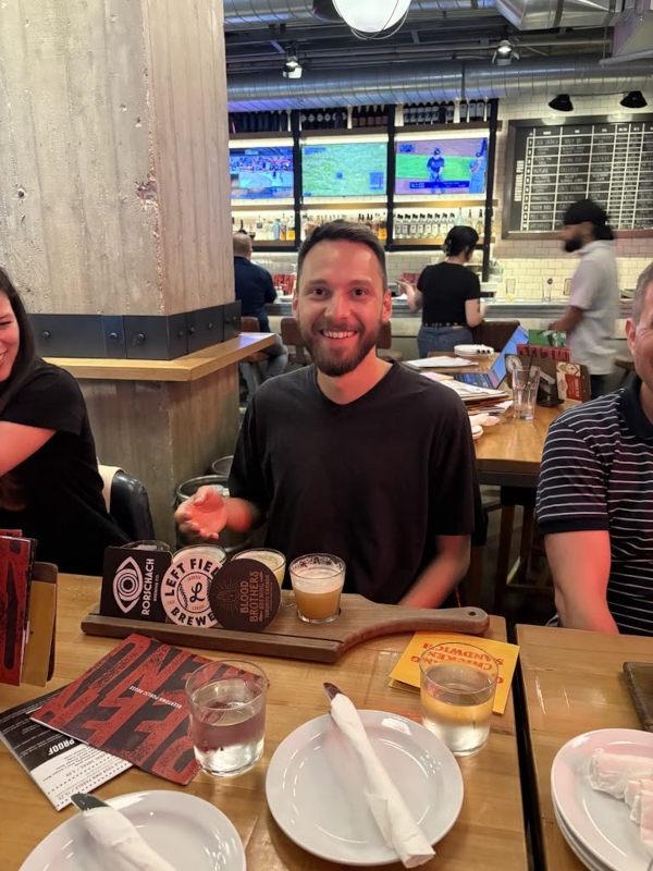 Me sitting at a desk with 4 small glasses of beer in front of me
